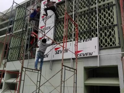 Tukang memasang panel ACP Seven dari perancah