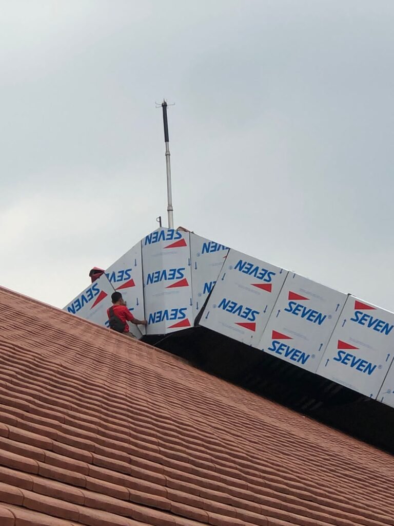 Panel ACP Seven diangkat ke atas atap saat pemasangan